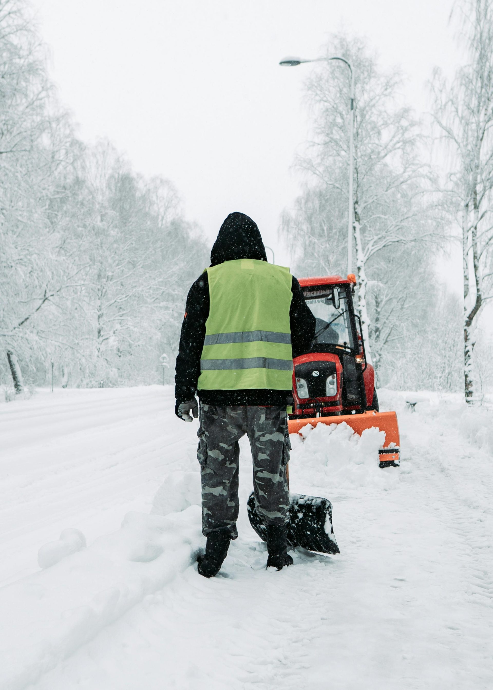 Ein Arbeiter räumt mit einem Schneepflug eine verschneite Straße in Litauen und demonstriert damit die winterliche Straßeninstandhaltung.